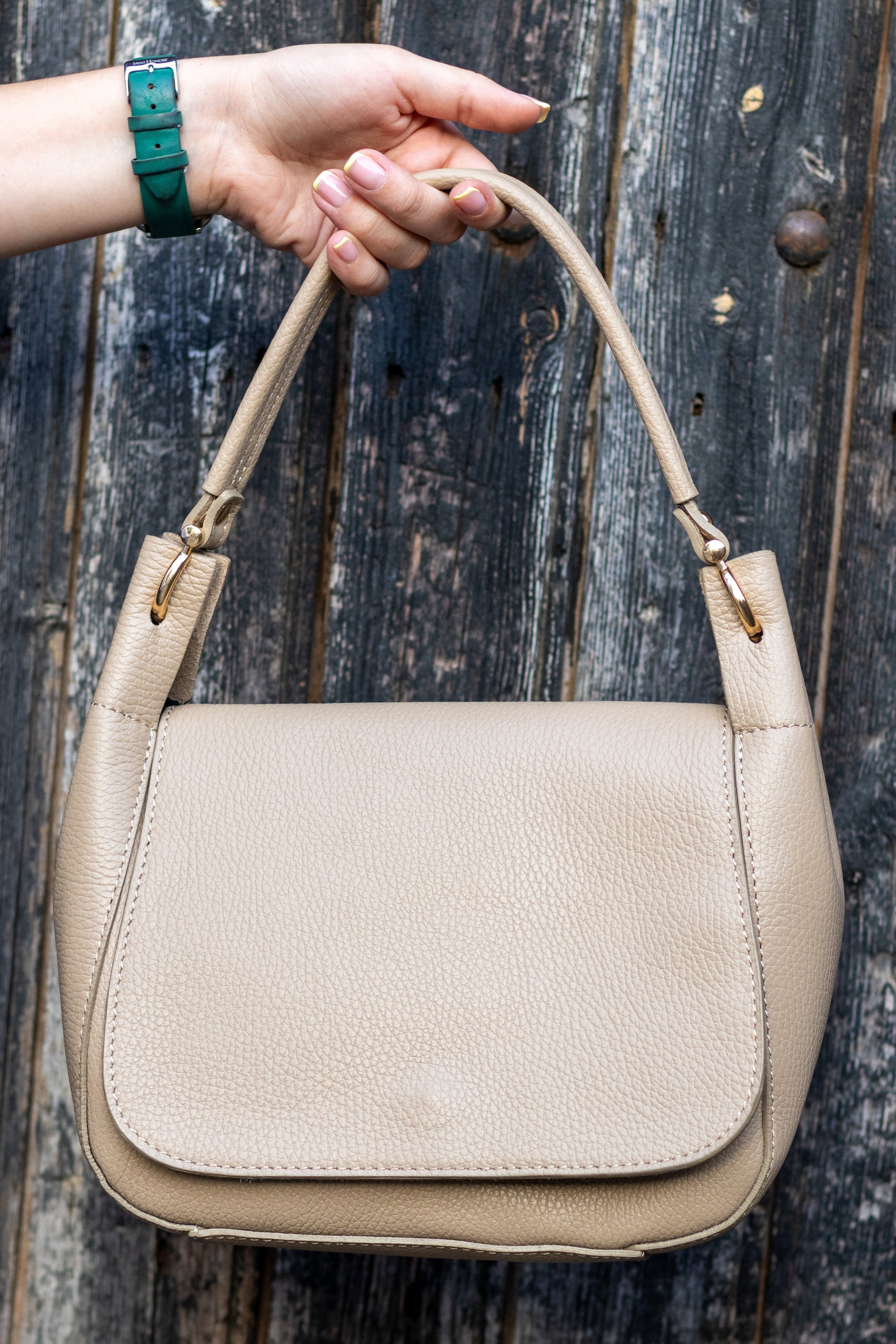 Sac Naomi cappuccino suspendu à la main – ambiance urbaine, cuir grainé visible